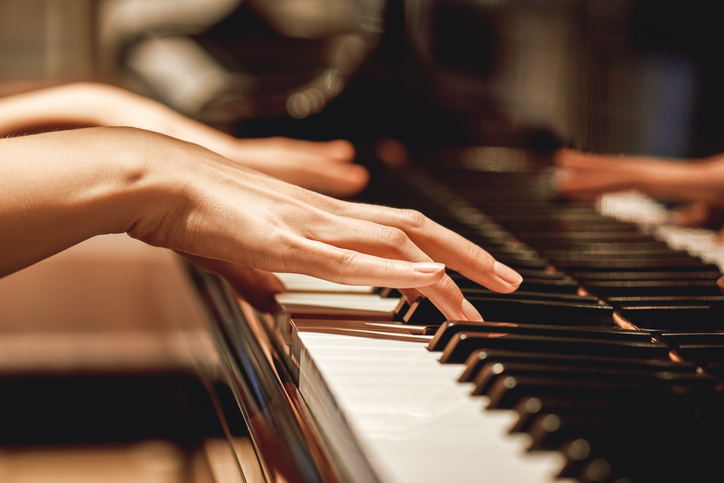 dłonie kobiety na klawiszach fortepianu